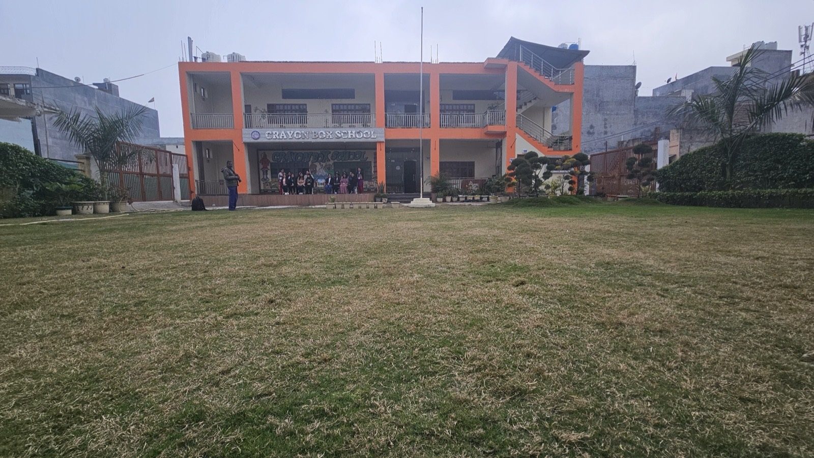 Full view of the two-storey Crayon Box School building and landscaped lawns in Burari Delhi